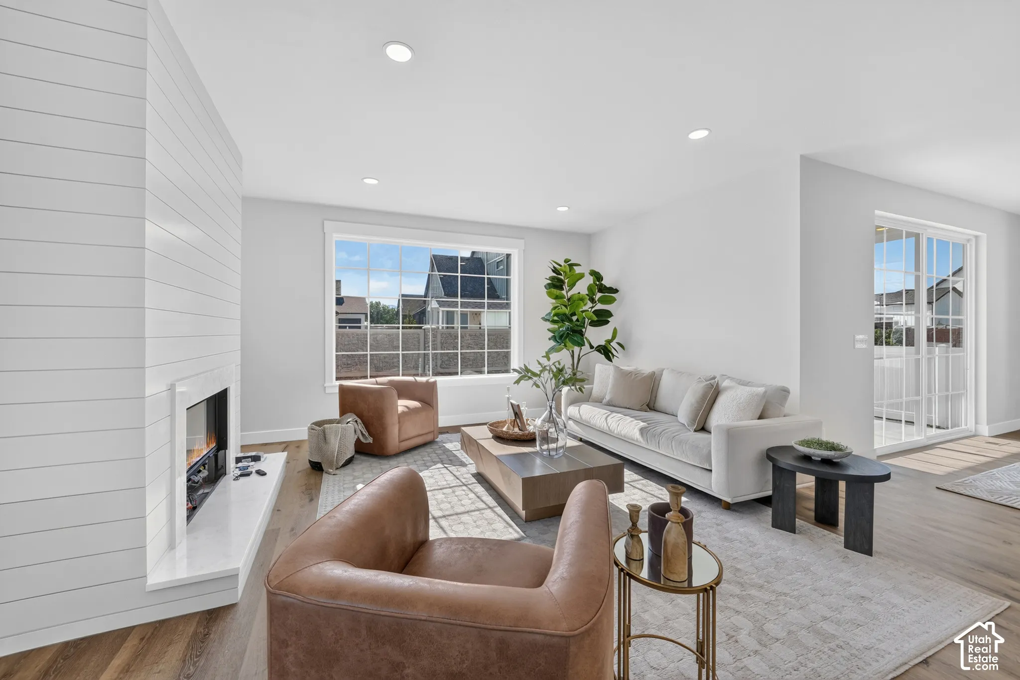 Spacious living area featuring light wood-finish flooring and recessed lighting