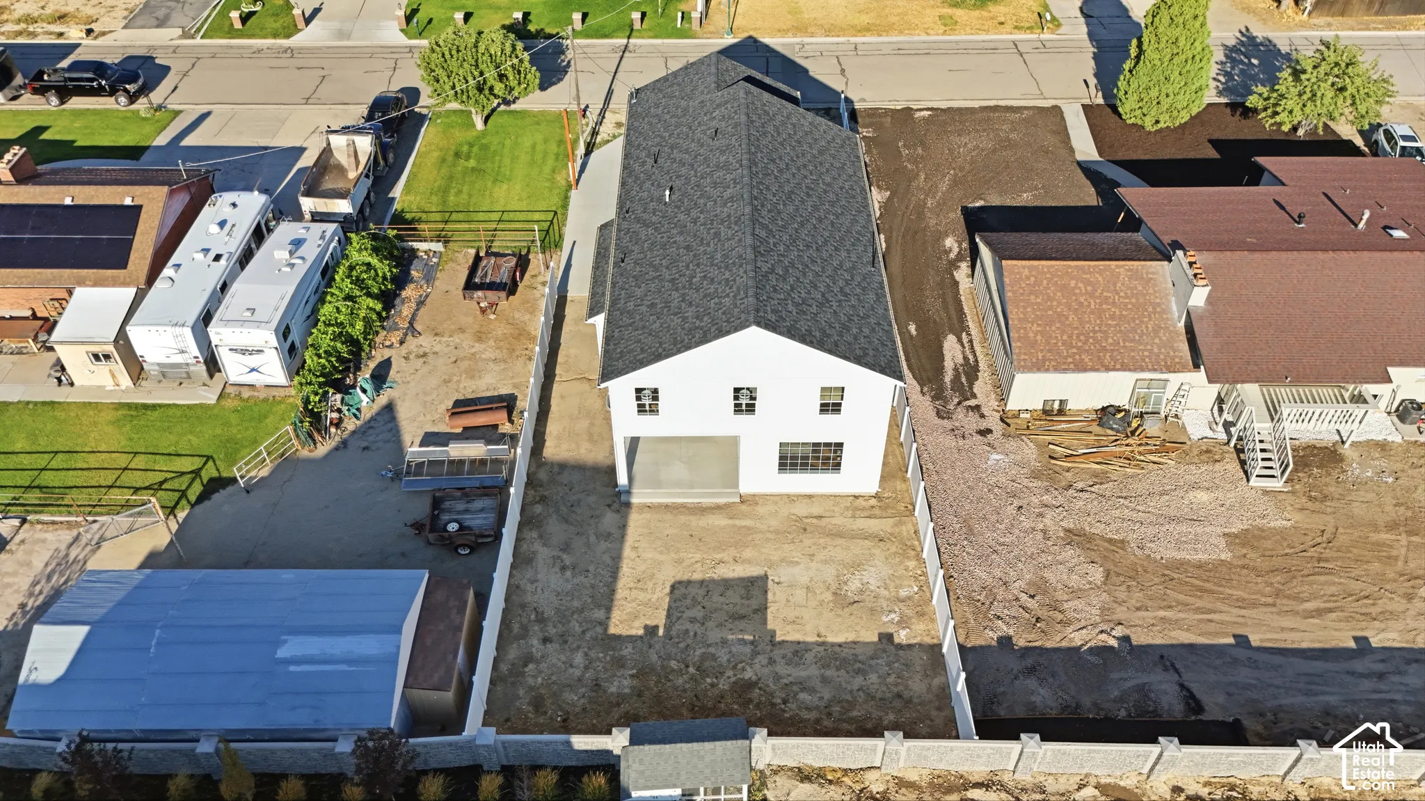 Newly constructed home with a modern white exterior and a dark shingled roof