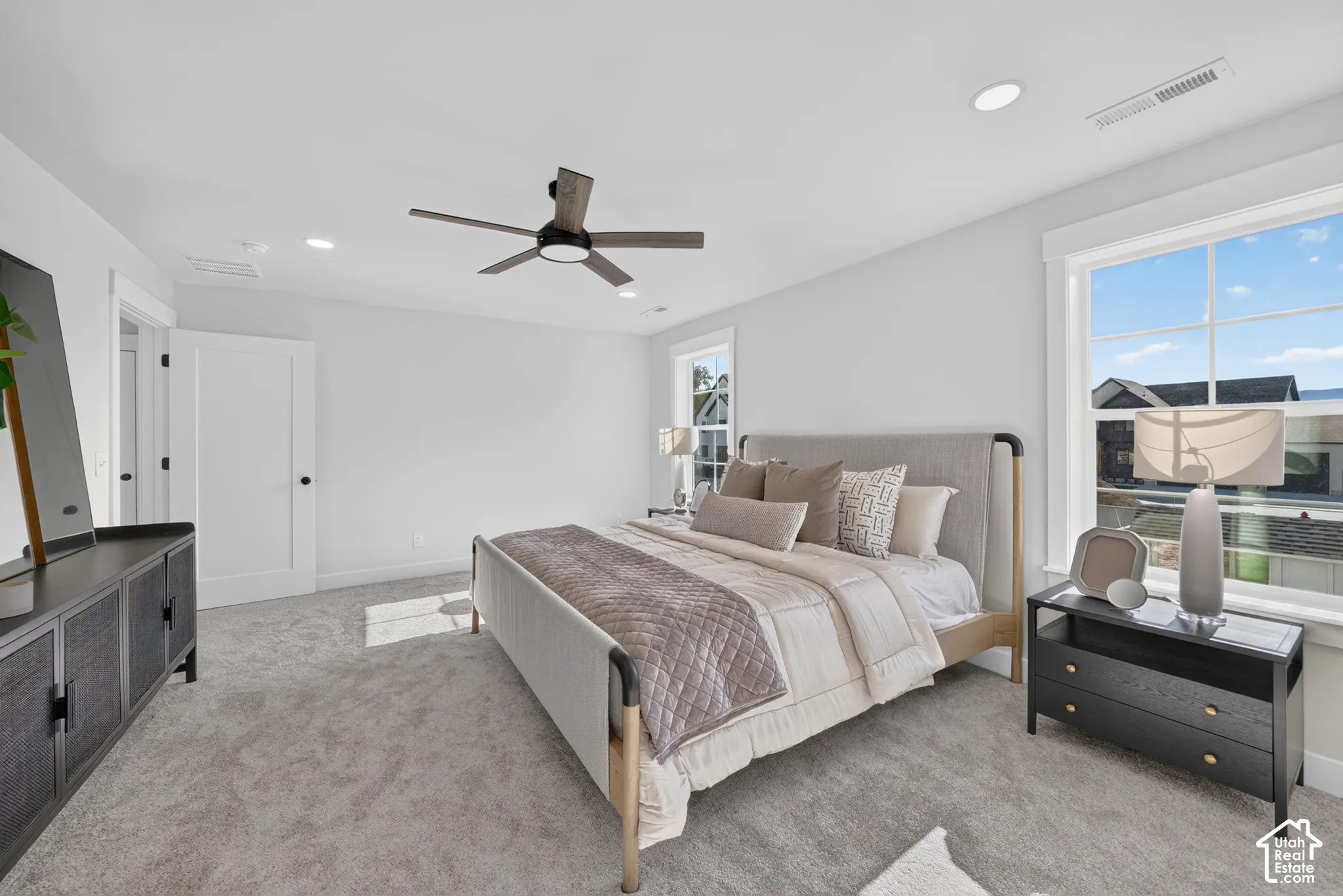 Spacious room featuring light gray carpeting, recessed lighting, and a modern ceiling fan