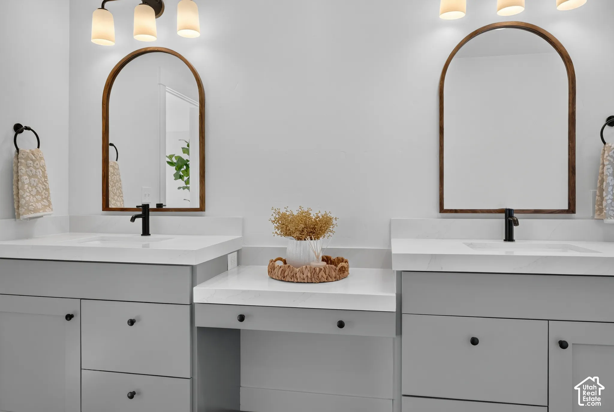 Dual vanity with gray cabinetry, white countertops, and integrated sinks