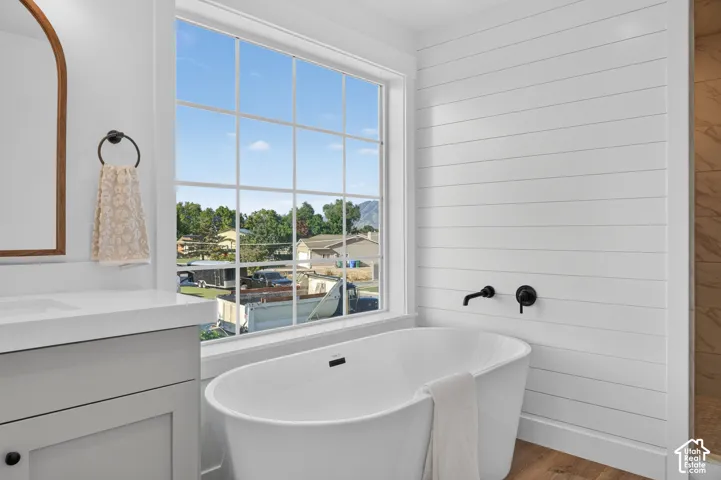 Freestanding soaking tub with matte black fixtures, set against a shiplap accent wall