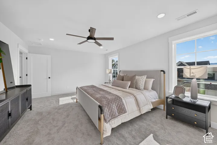 Spacious room featuring light gray carpeting, recessed lighting, and a modern ceiling fan