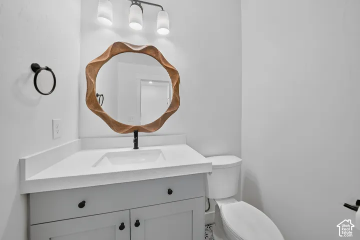 Bathroom vanity featuring a white countertop with an integrated sink and a black wall-mounted faucet