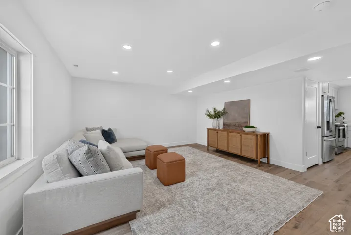 Spacious room featuring wood-finish flooring, recessed lighting, and a window with white trim