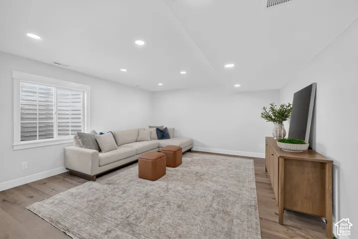 Spacious interior featuring recessed lighting, wood-finish flooring, and white baseboards