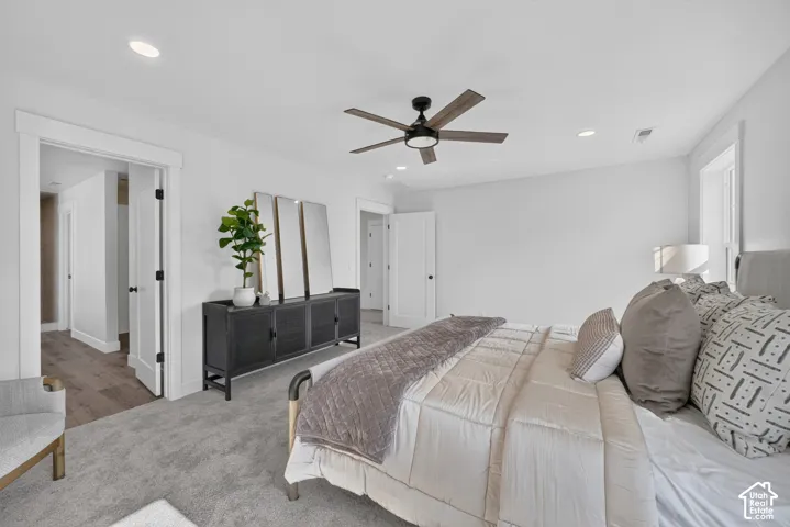 Spacious room featuring neutral carpeting, recessed lighting, a ceiling fan, and white trim throughout
