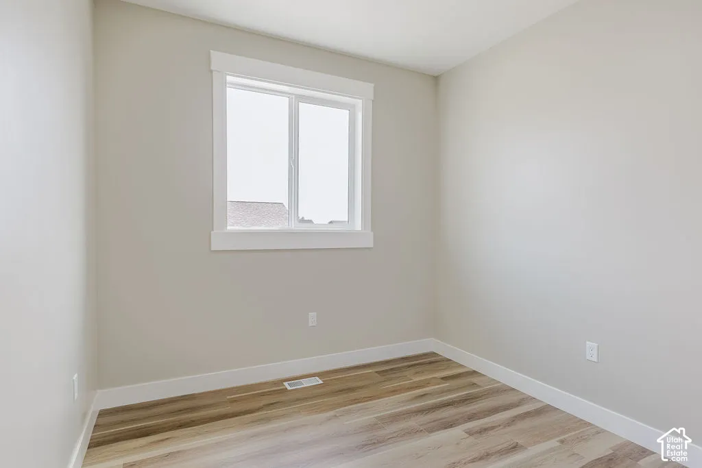 Neutral toned walls complemented by wood-finish flooring