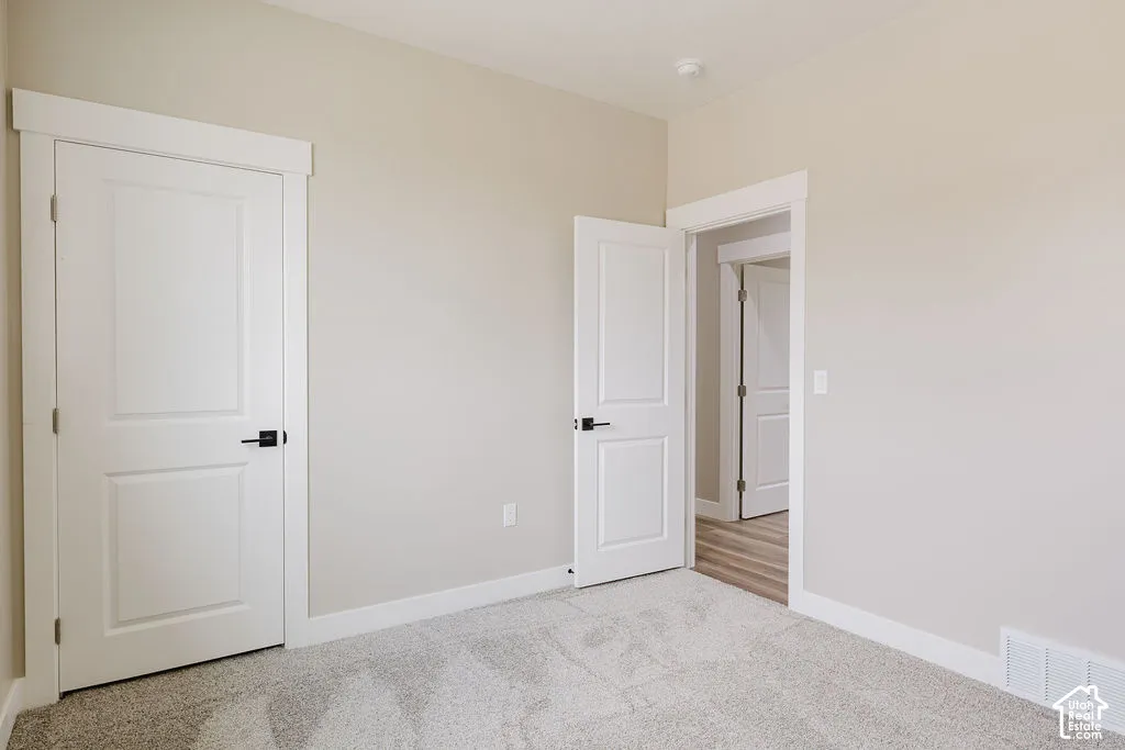 Carpeted interior room featuring light neutral wall paint