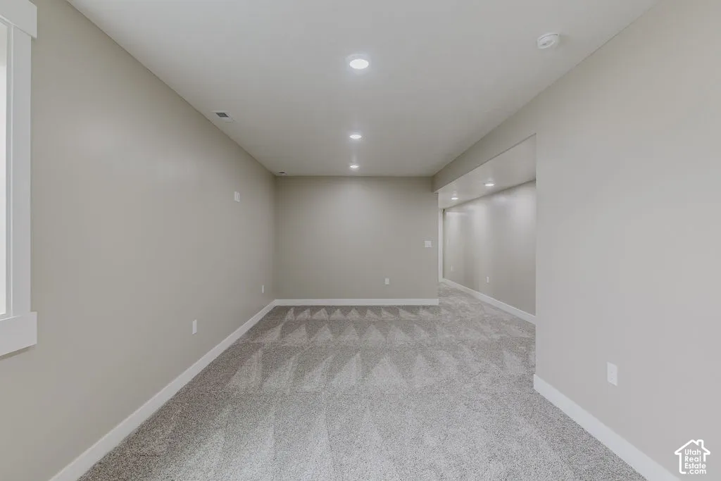 Spacious room featuring neutral paint, recessed lighting, white baseboards, and patterned carpet