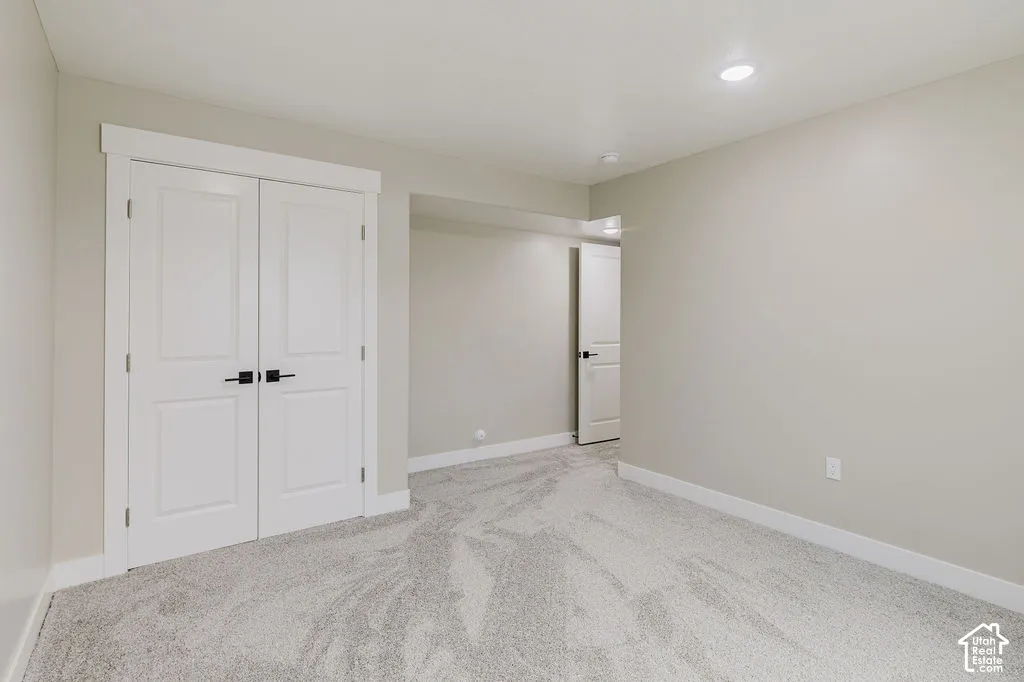 Neutral-toned room featuring light gray carpeting, white baseboards, and light gray walls