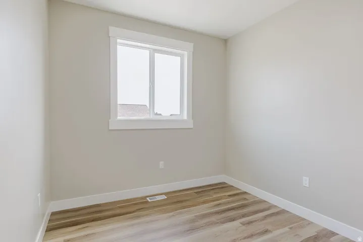 Neutral toned walls complemented by wood-finish flooring
