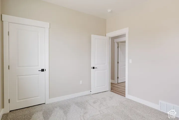 Carpeted interior room featuring light neutral wall paint