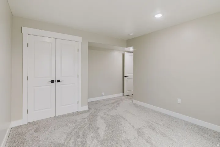 Neutral-toned room featuring light gray carpeting, white baseboards, and light gray walls