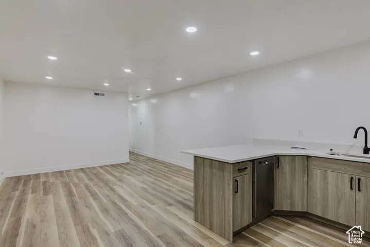Spacious room with wood-finish flooring, recessed lighting, and white walls