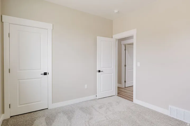 Carpeted interior room featuring light neutral wall paint