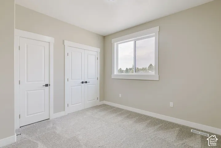 Neutral-toned walls complement plush grey carpeting
