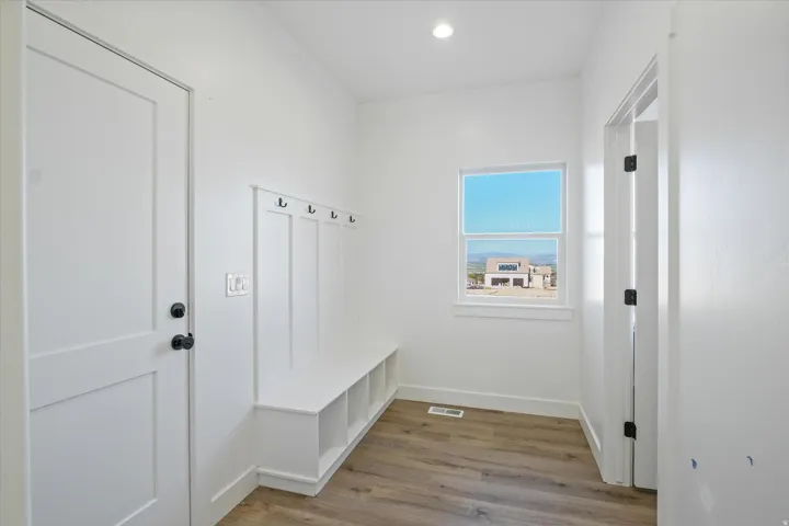 Mudroom featuring a built-in bench with storage cubbies and wall-mounted coat hooks
