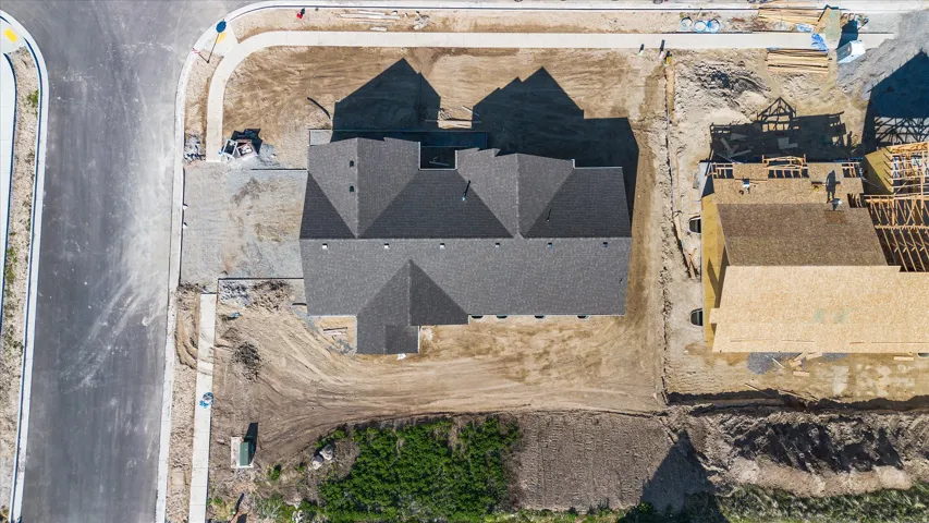 New construction property featuring a dark shingle roof and a concrete driveway