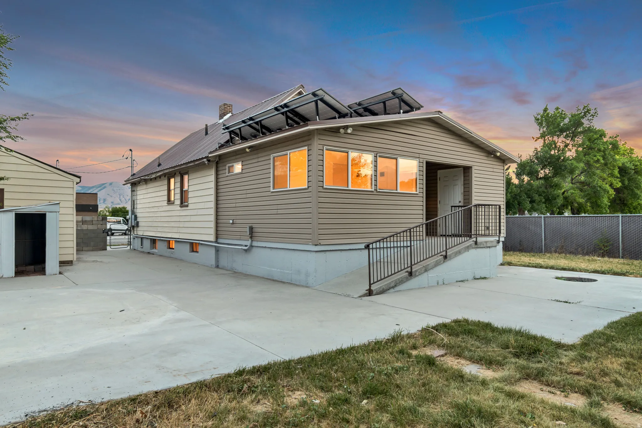Ranch-style exterior with multi-toned siding, a metal roof, and integrated solar panels