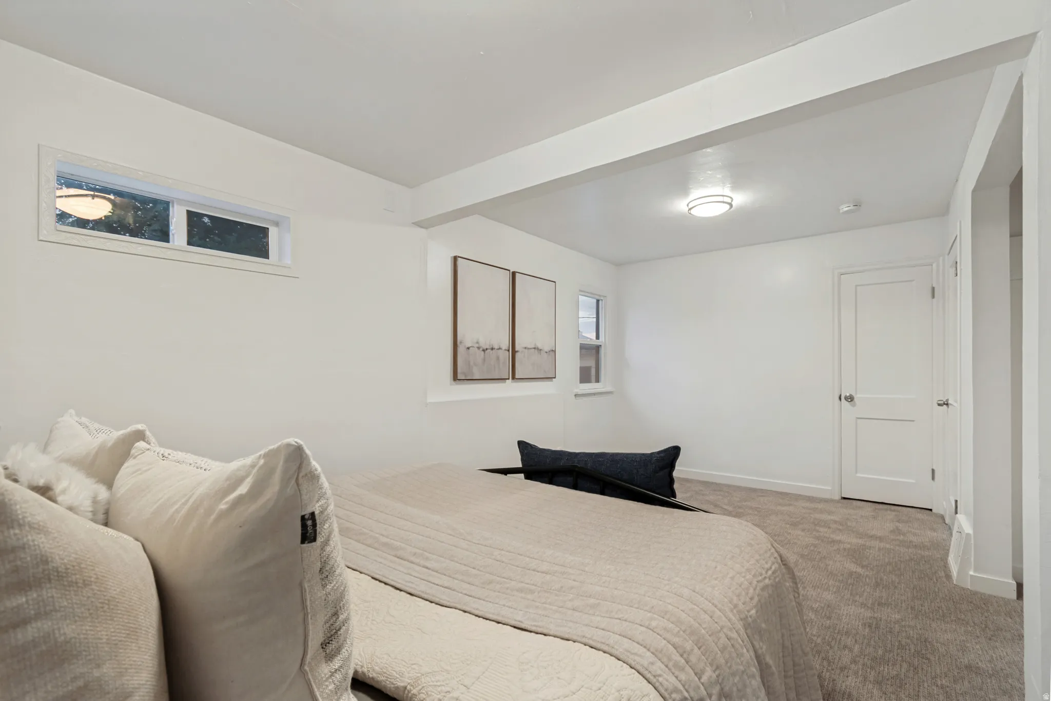 Carpeted room featuring white walls, a recessed transom window, and a flush-mount ceiling light