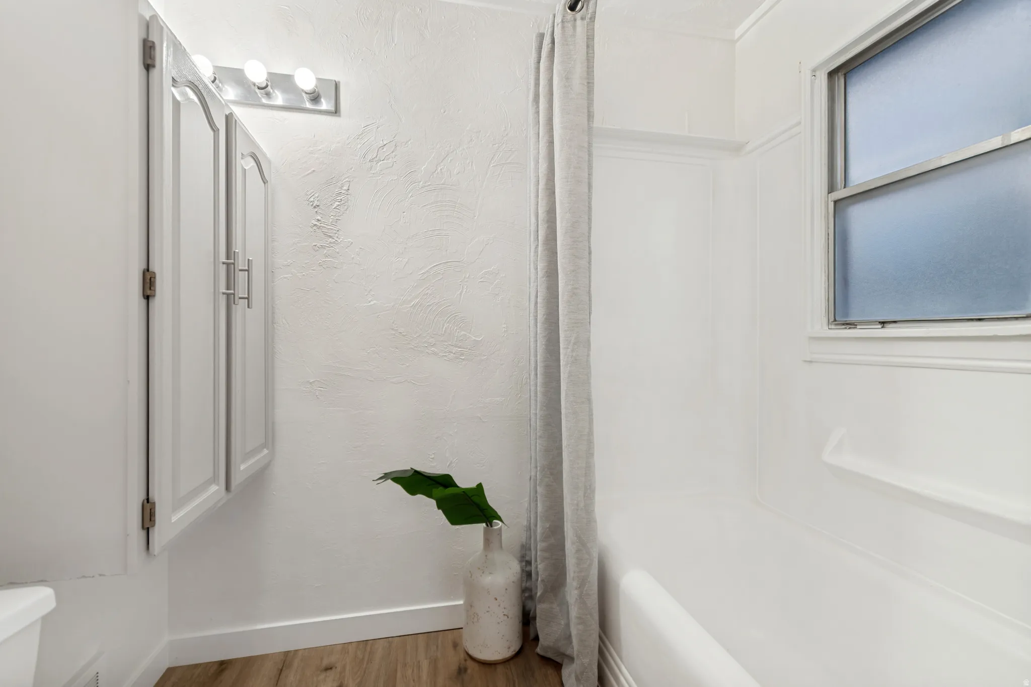 Wood-finish flooring complemented by white baseboards