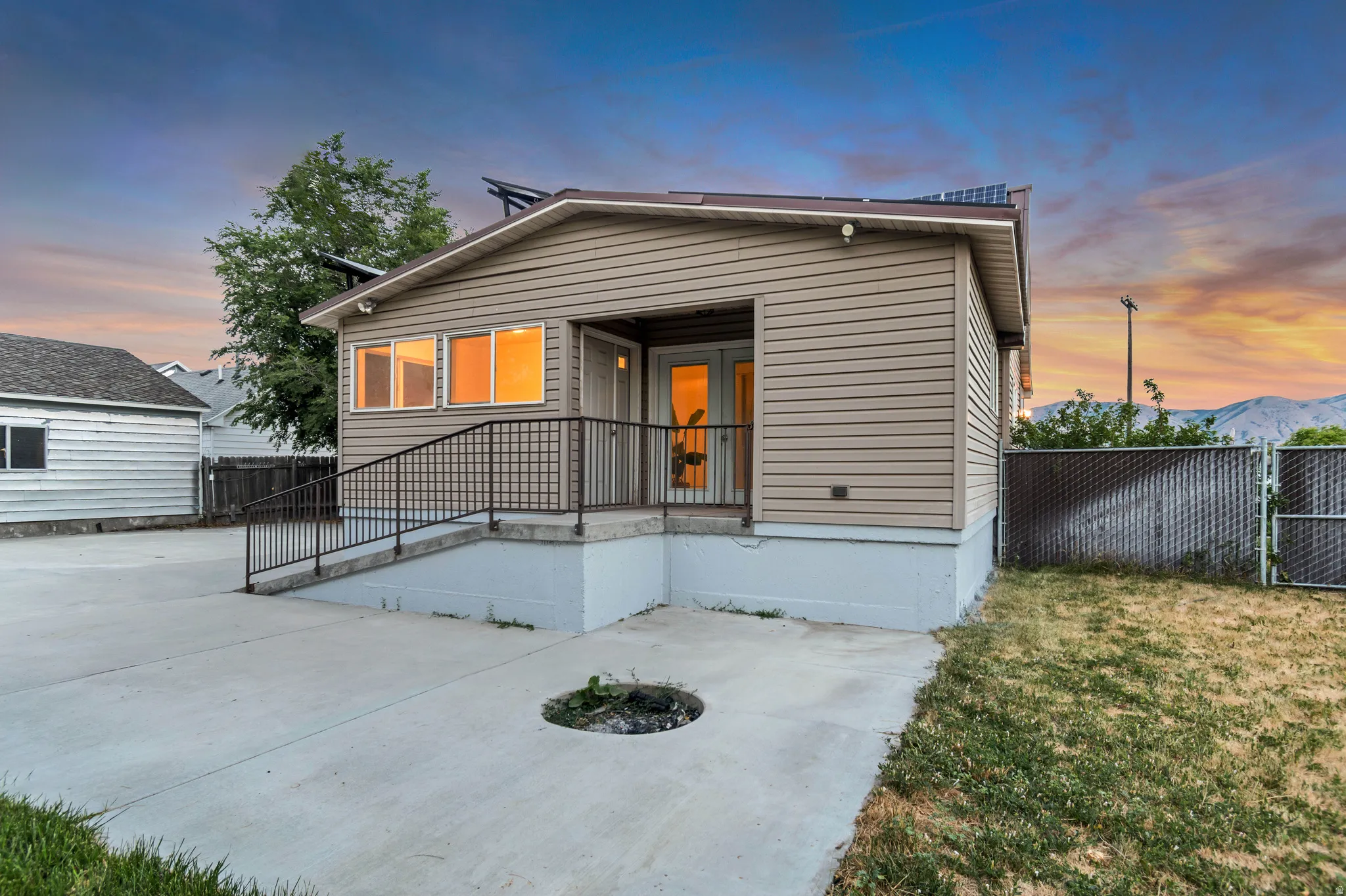 Exterior featuring horizontal siding, a concrete patio, and a ramp entrance with a metal handrail