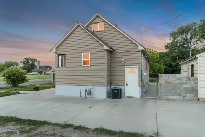 Exterior featuring tan horizontal siding, a gabled roofline, and a concrete driveway