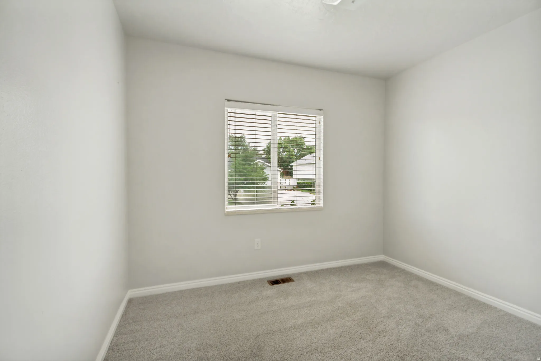 Neutral wall finishes complemented by light gray carpeting