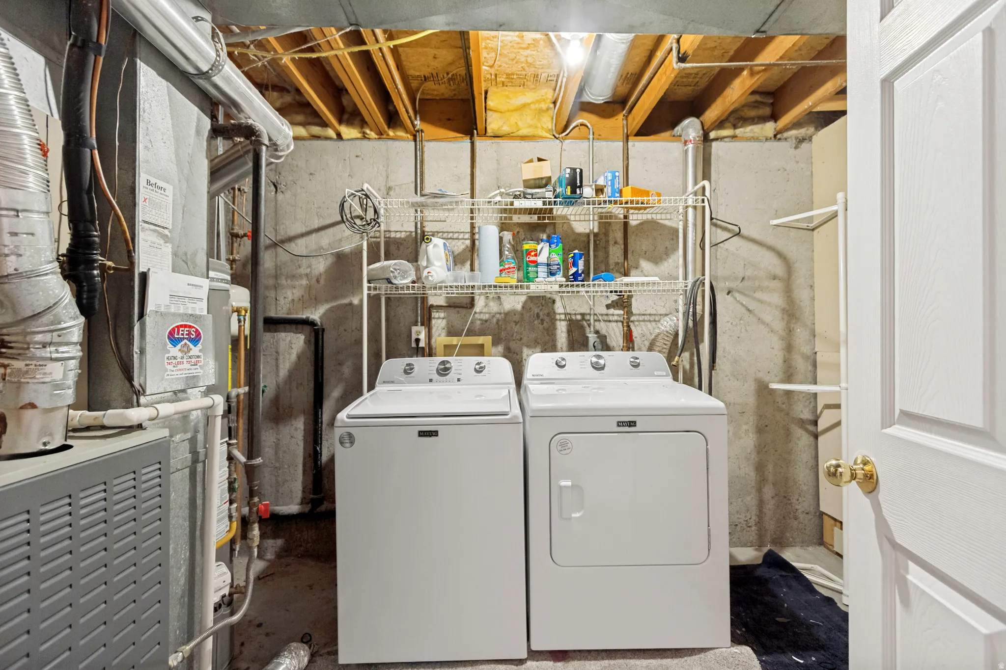 Laundry area featuring a side-by-side washer and dryer, wire shelving for storage, and exposed ceiling joists