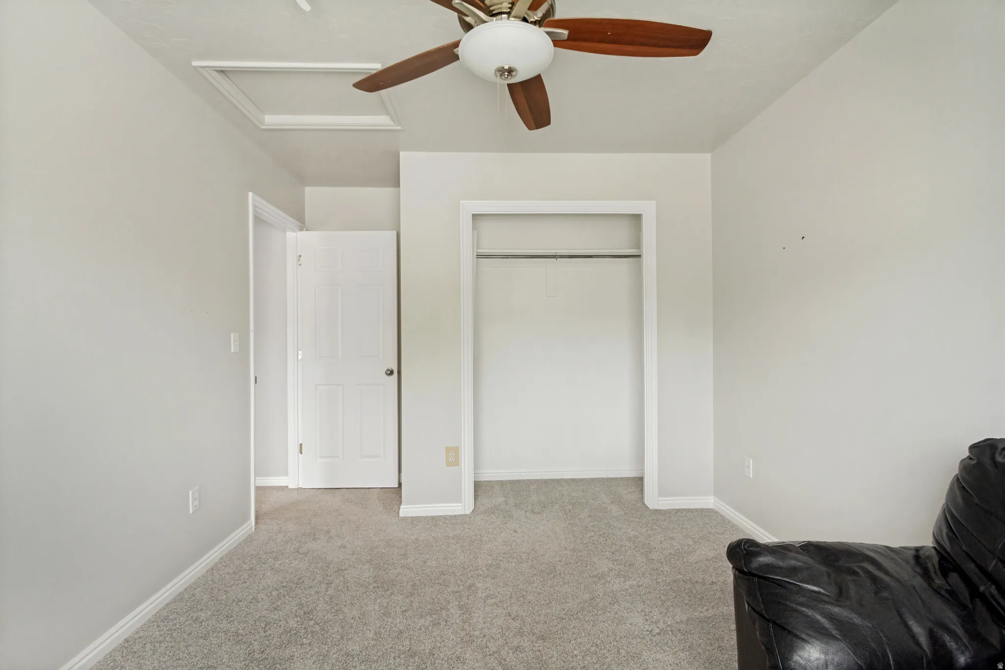 Neutral wall tones, gray carpeting, open closet space, a ceiling fan, and white trim molding