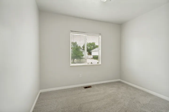 Neutral wall finishes complemented by light gray carpeting