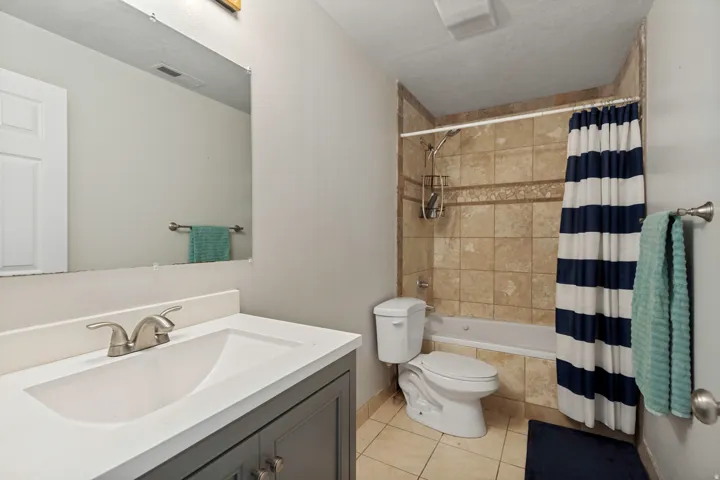 Bathroom featuring a single vanity with a white countertop and undermount sink