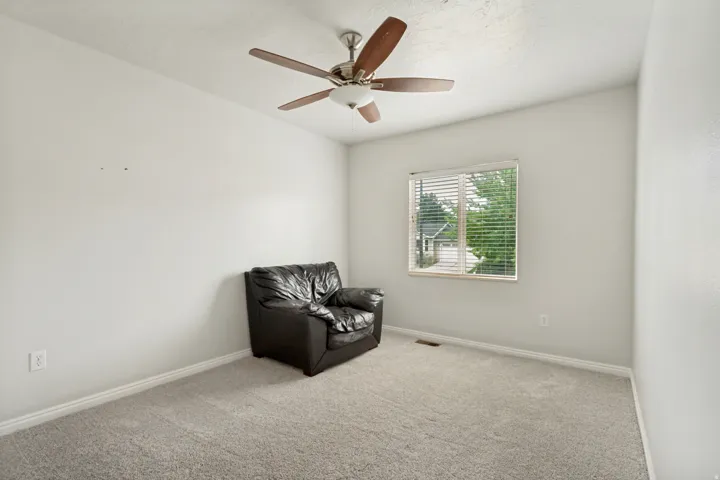 Carpeted room with a single window featuring blinds