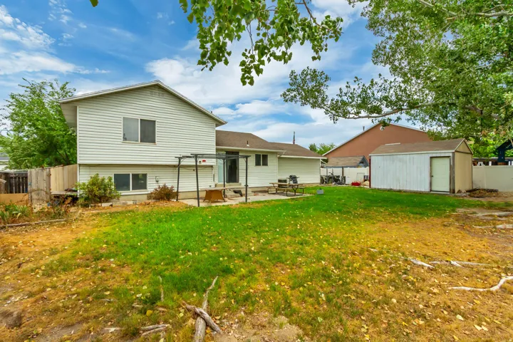 Spacious backyard featuring a large lawn area and established trees