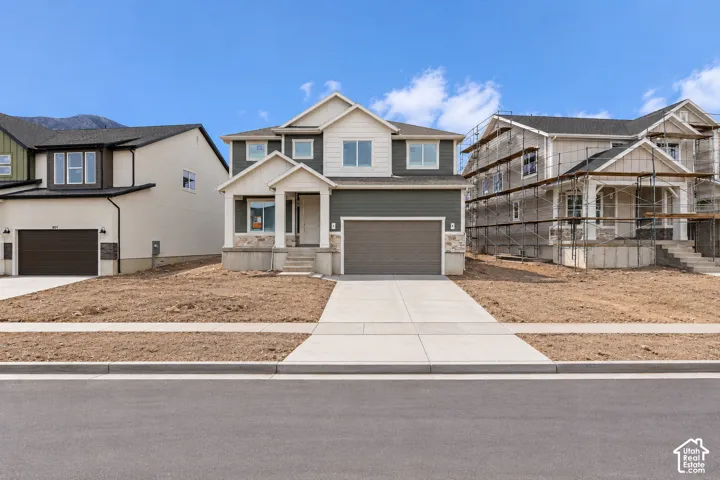 Two-story residence featuring a combination of horizontal lap siding and stone veneer, a covered front entryway, and an attached two-car garage