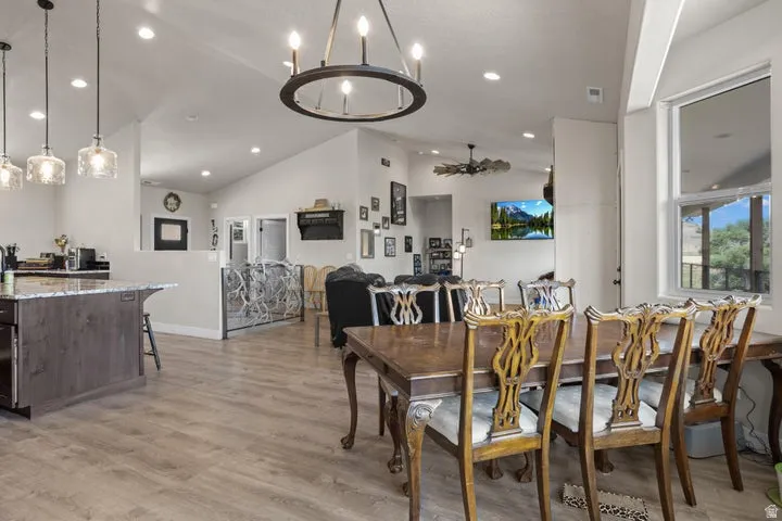 Spacious dining area featuring wood-finish flooring and a contemporary chandelier