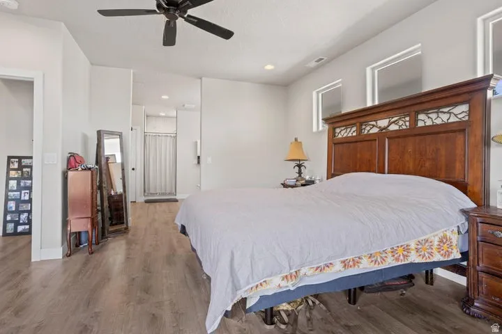 Spacious interior featuring wood-finish flooring, recessed lighting, a ceiling fan, and high windows for ample natural light