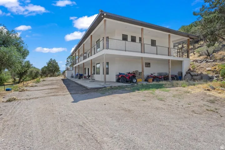 Two-story stucco property featuring a lower-level covered patio and an upper-level covered balcony