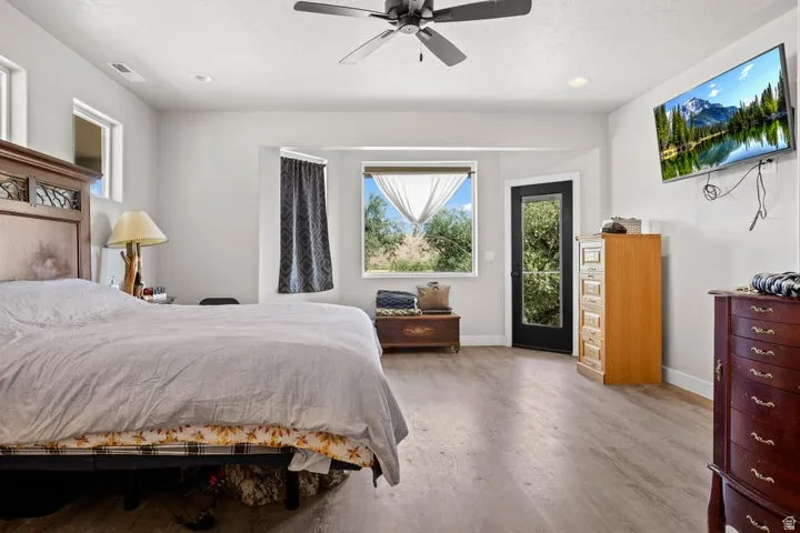 Spacious room featuring wood-finish flooring and a ceiling fan