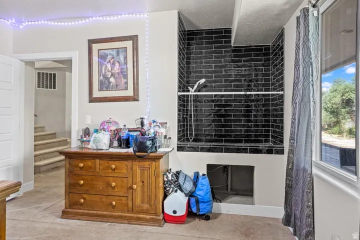 Black subway tile shower surround with a built-in shelf and handheld shower fixture
