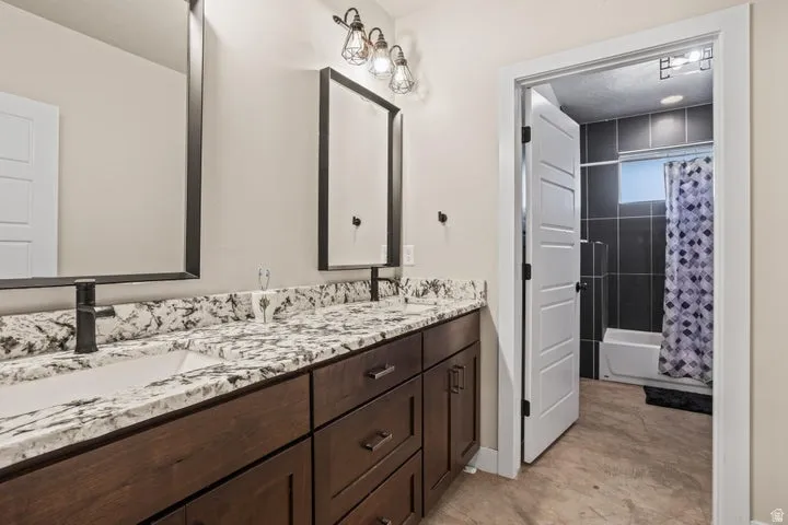 Double vanity with a patterned countertop, undermount sinks, and matte black faucets