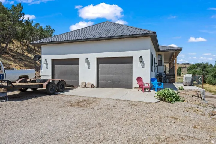 Exterior featuring a two-car garage with individual doors, a metal roof, and stucco siding