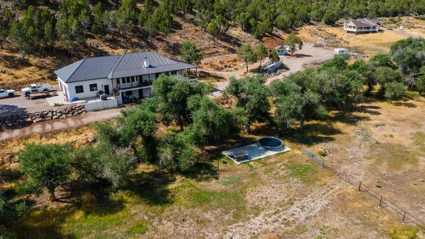 Expansive property featuring a contemporary residence with a dark metal roof, white siding, and an attached garage