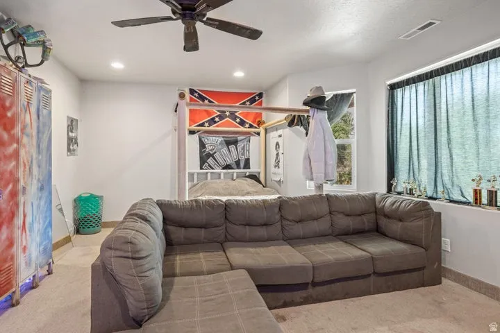 Carpeted room featuring a ceiling fan with light, recessed lighting, and a window with a sill