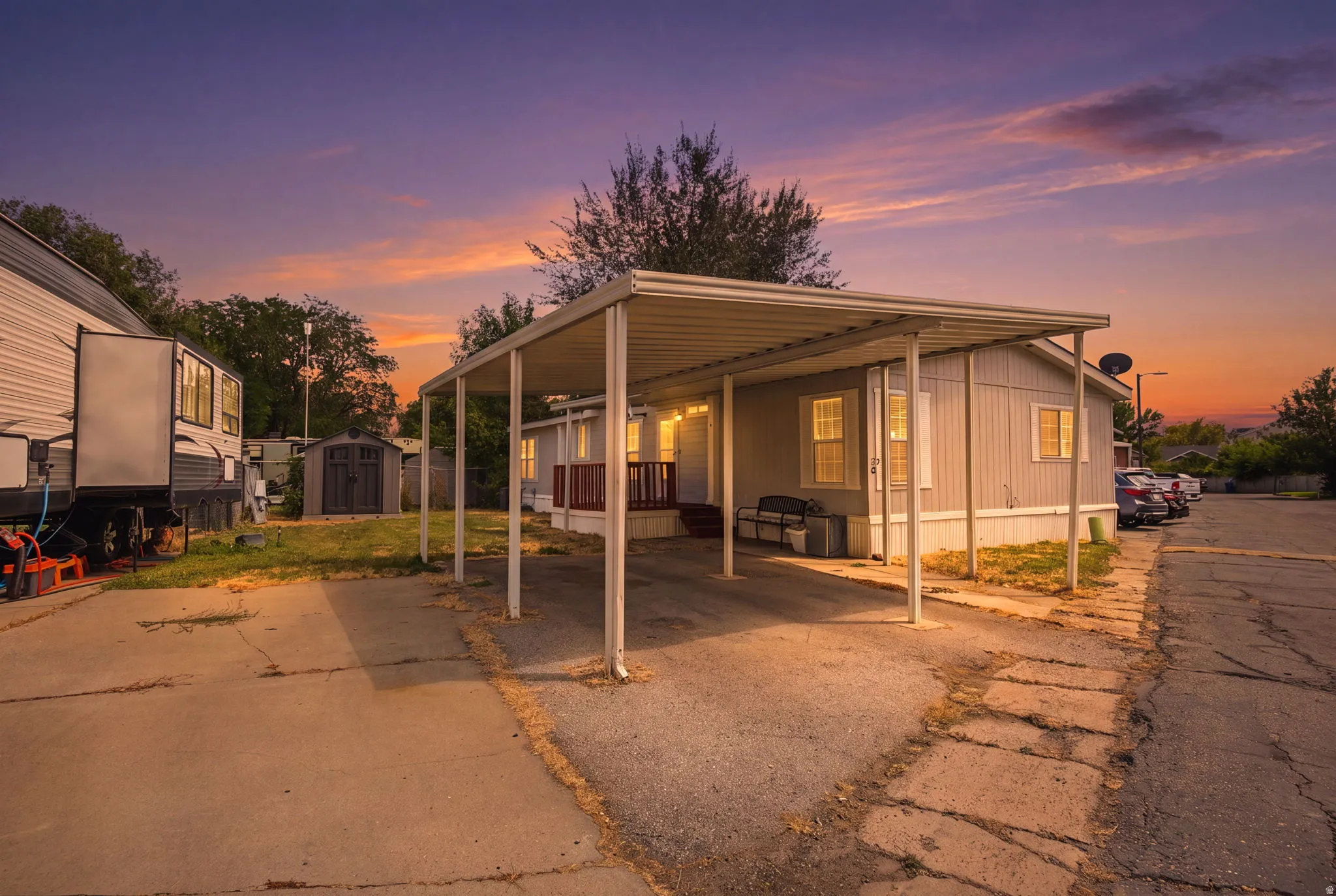 Single-story home featuring light grey siding and a covered carport