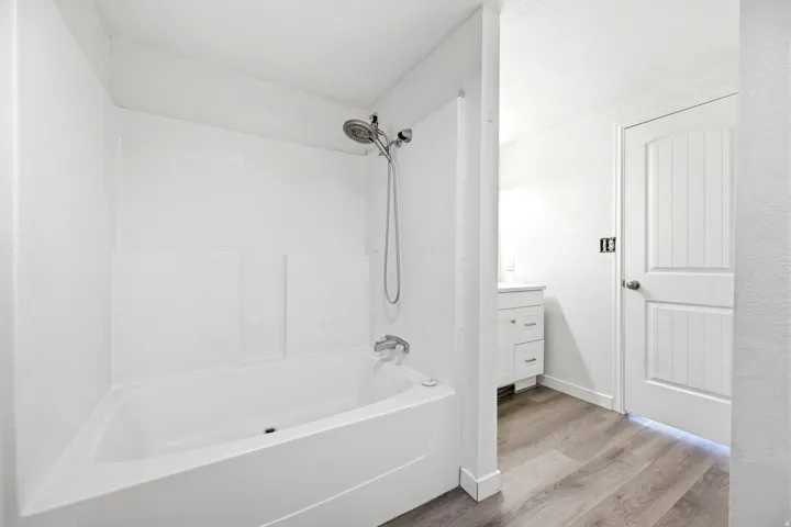 Bathtub and shower combination featuring a white surround
