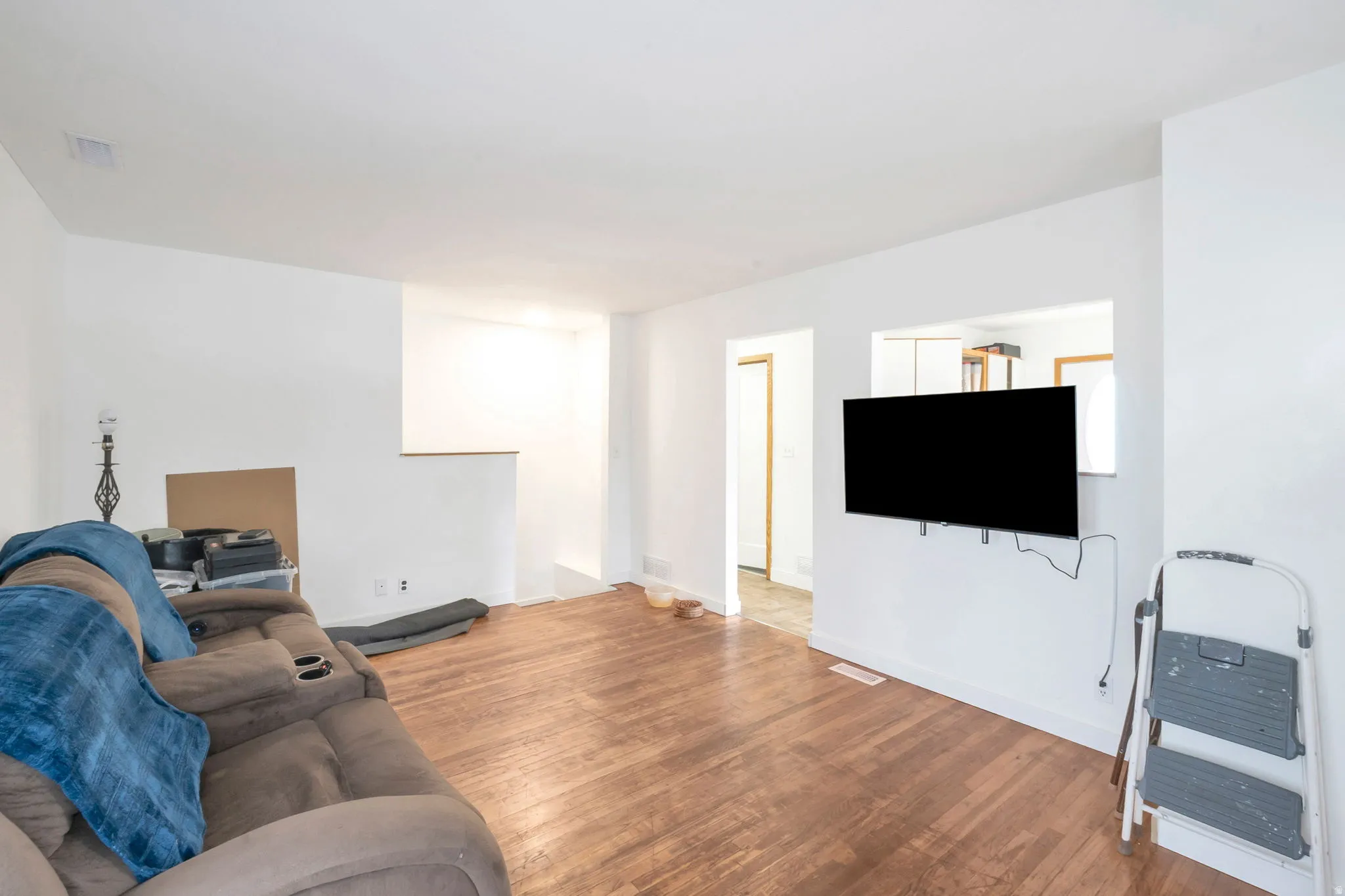 Wood-finish flooring, white painted walls, and an interior pass-through window