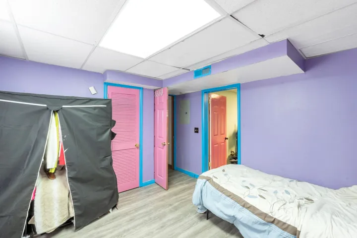 Drop ceiling with recessed lighting, wood-finish flooring, and painted interior doors