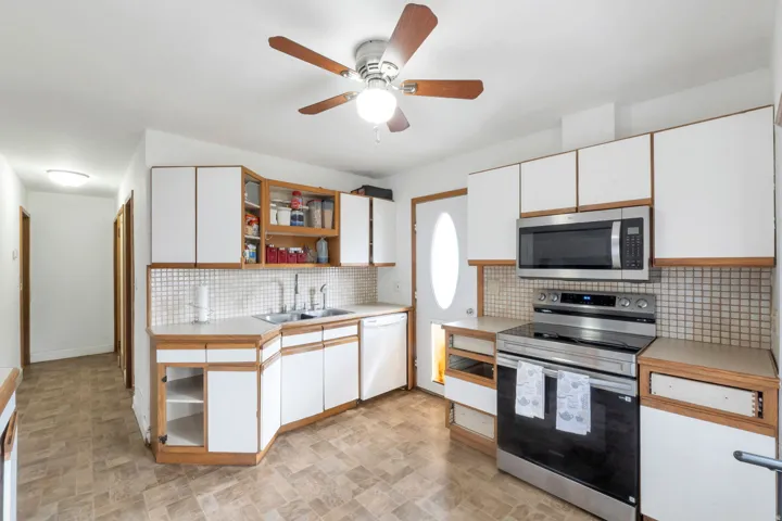 Kitchen featuring white cabinetry, stainless steel range, and stainless steel microwave