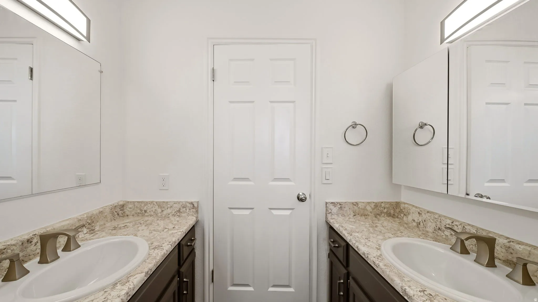 Dual vanity with undermount sinks, bronze-finish faucets, and patterned countertops